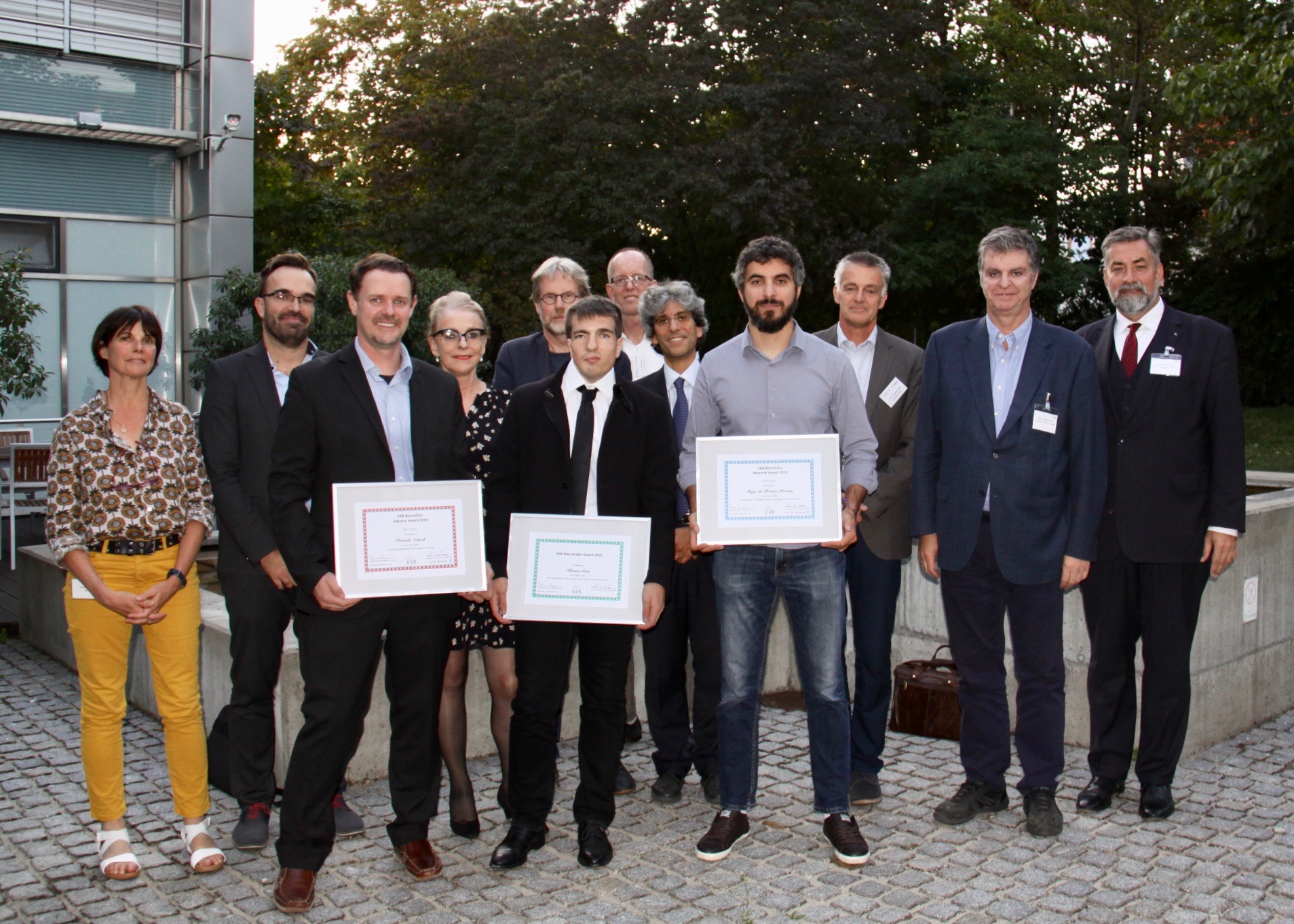 [Photo] The winners of the European Biometrics Max Snijder, Research, and Industry Awards 2019 Patrick Schuch, Klemen Grm and Tiago de Freitas Pereira together with Claude Bauzou (IDEMIA), Vitomir Struc (University of Ljubljana), Marianne Volonte (mymarc), Raymond Veldhuis (University of Twente), Tom Kevenaar (GenKey), Patrizio Campisi (University University of Roma TRE), Christoph Busch (Norwegian University of Science and Technology) and Alexander Nouak (EAB chair)